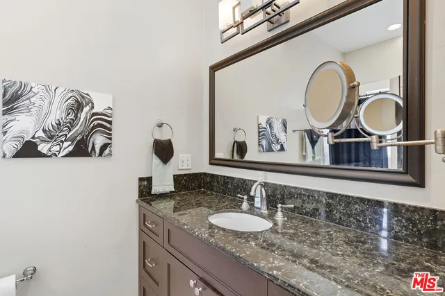 a bathroom with a granite countertop double vanity sinks and a mirror