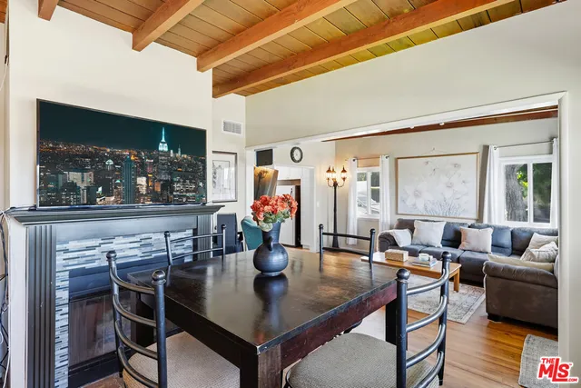 a living room with furniture a flat screen tv and a floor to ceiling window