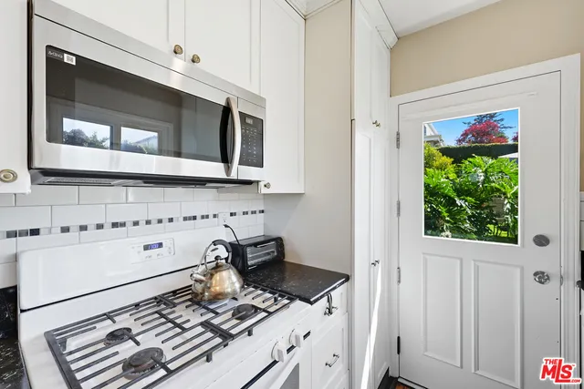 a kitchen with stainless steel appliances granite countertop a stove and a microwave