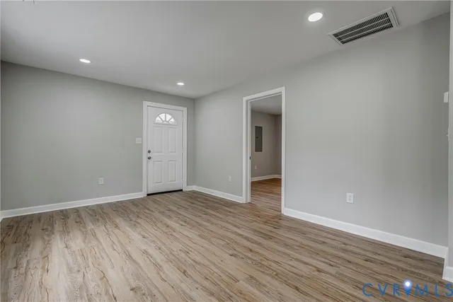 a view of an empty room with wooden floor