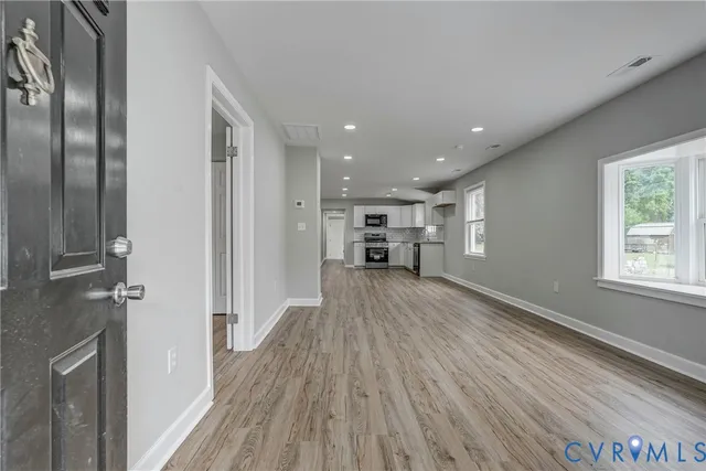 a view of empty room with wooden floor