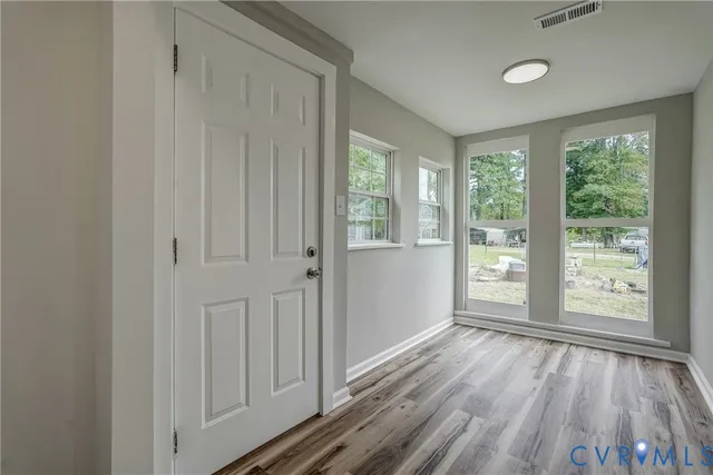 a view of a room with wooden floor and windows