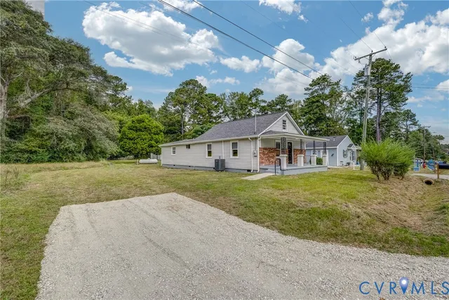 a front view of a house with a garden and trees