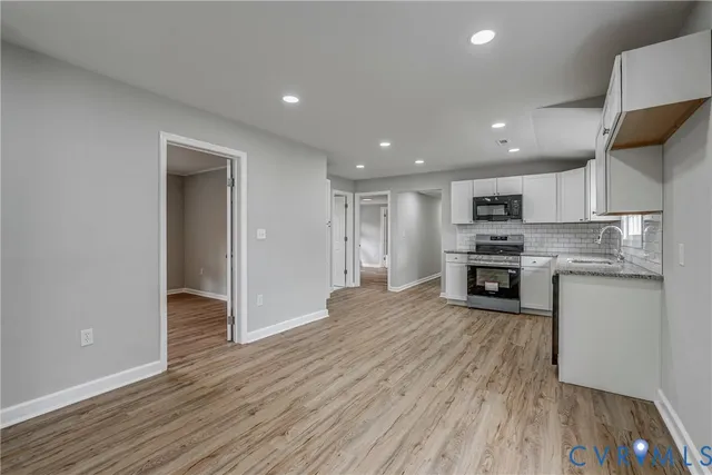 a kitchen with stainless steel appliances granite countertop a refrigerator and a stove top oven