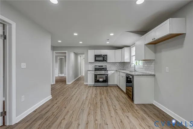 a kitchen with a refrigerator and a stove top oven