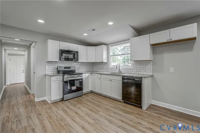 a kitchen with a sink a microwave and cabinets