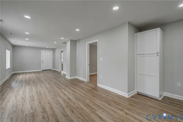 a view of an empty room with wooden floor