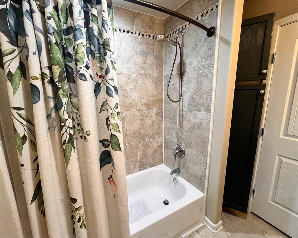 420 Sessums Road Springtown, TX 76082 - Photo 30 of 40 Full bath with shower / bath combination with curtain and light tile patterned flooring