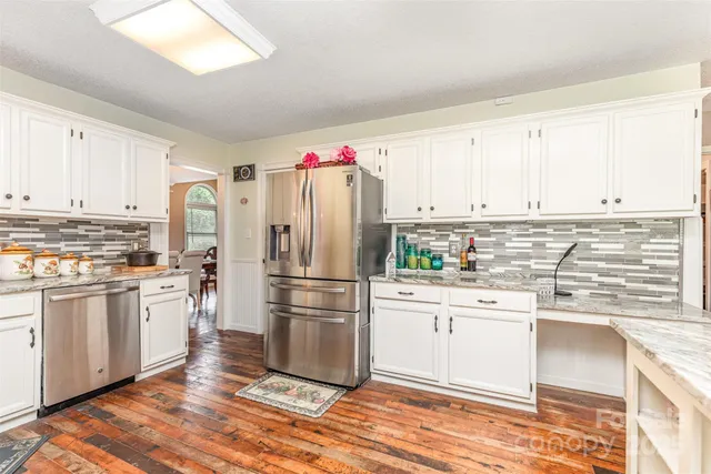 a kitchen with white cabinets and stainless steel appliances