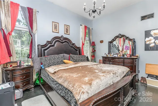 a bedroom with a bed and a chandelier