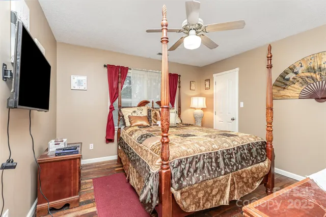 a bedroom with bed and flat tv screen