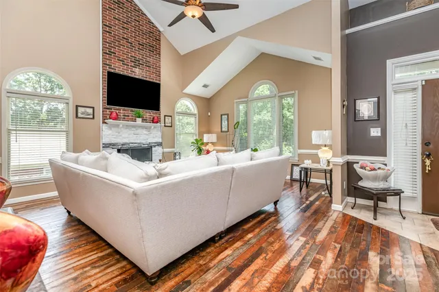 a living room with furniture a flat screen tv and a fireplace
