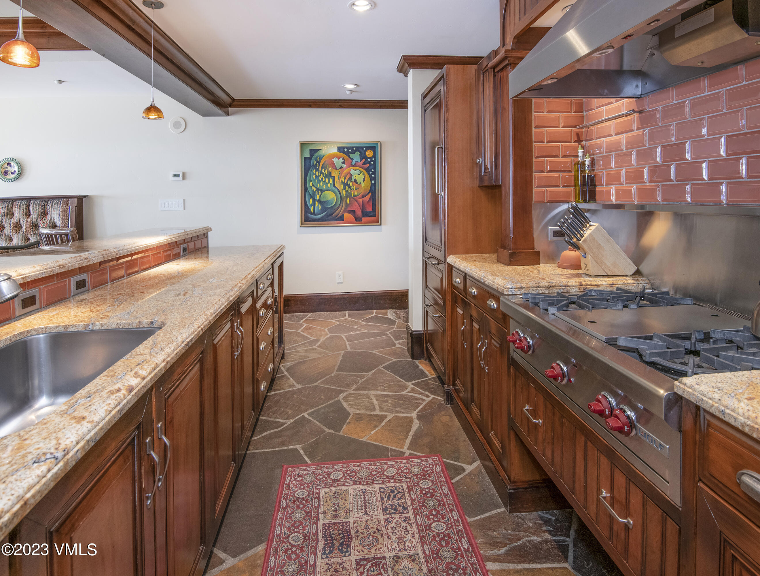 1 Willow Bridge Road, Unit 32F Vail, CO 81657 - Photo 10 of 41 a kitchen with stainless steel appliances kitchen island granite countertop a stove a sink and a microwave