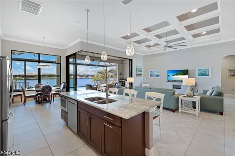 a kitchen with a counter space a sink appliances and living room view