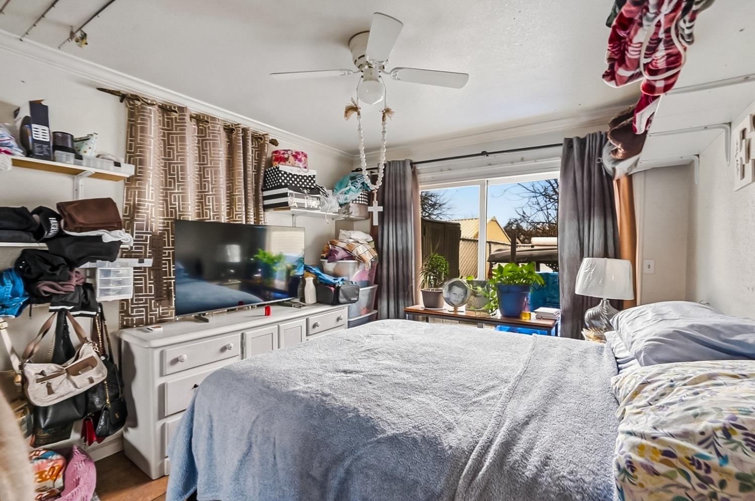 1829 River Road Modesto, CA 95351 - Photo 38 of 44 a bedroom with a bed a flat screen tv and a couch