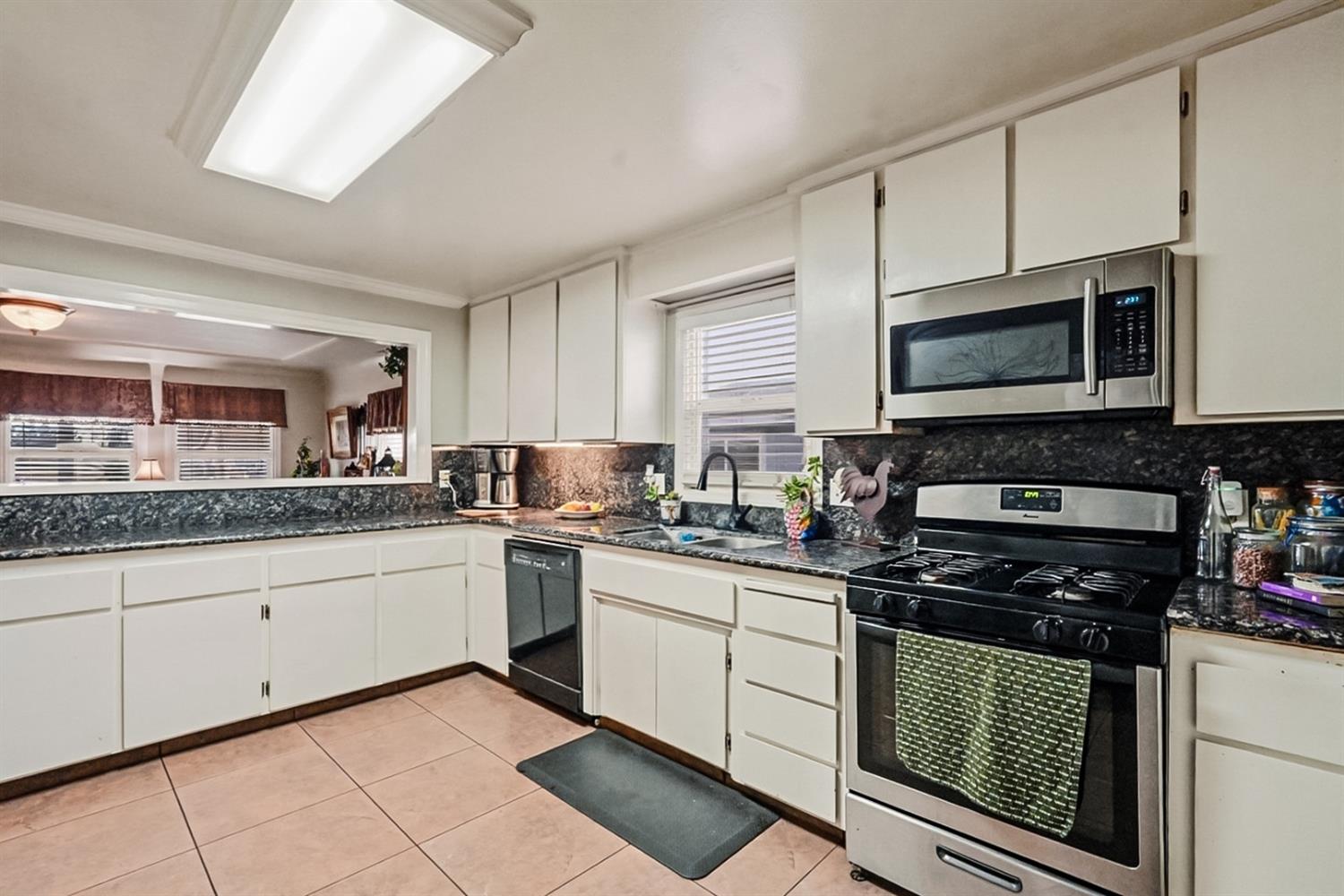 1829 River Road Modesto, CA 95351 - Photo 42 of 44 a kitchen with granite countertop cabinets stainless steel appliances and a window