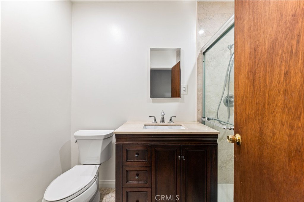 9063 Gotham Street Downey, CA 90241 - Photo 17 of 45 a bathroom with a toilet a sink and mirror
