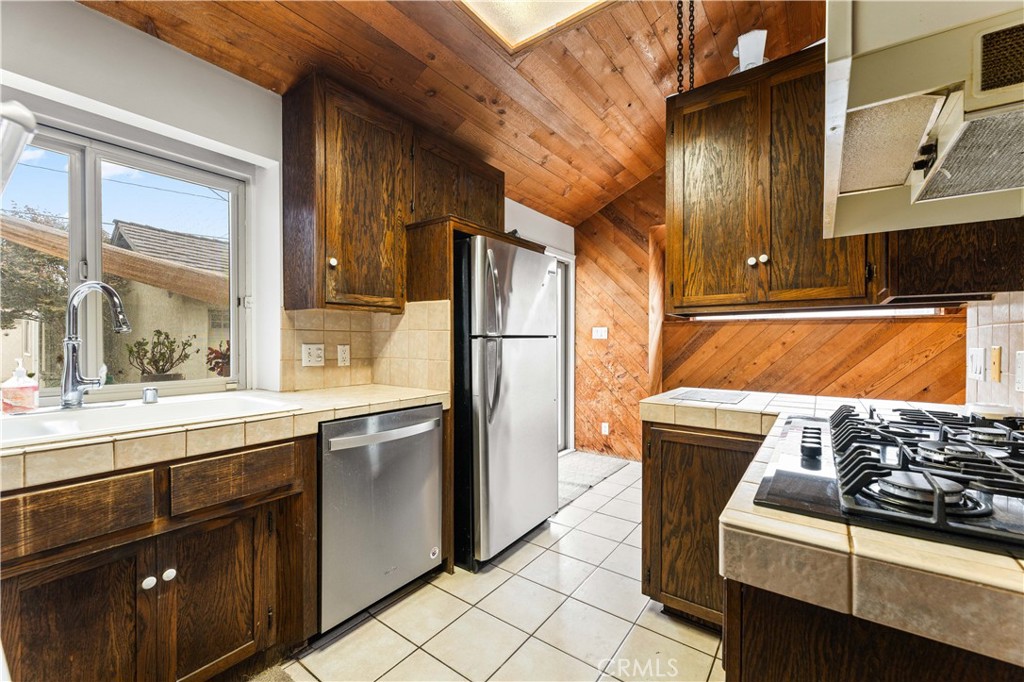 9063 Gotham Street Downey, CA 90241 - Photo 19 of 45 a kitchen with stainless steel appliances granite countertop a stove a sink and a refrigerator