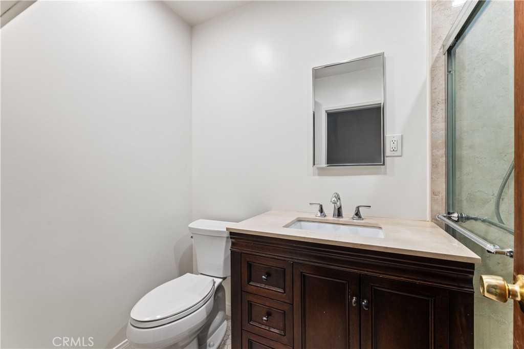 9063 Gotham Street Downey, CA 90241 - Photo 35 of 45 a bathroom with a toilet a sink and mirror