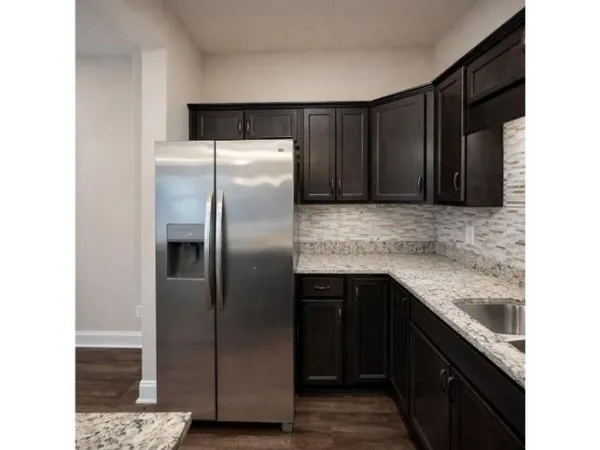 a kitchen with a refrigerator sink and cabinets