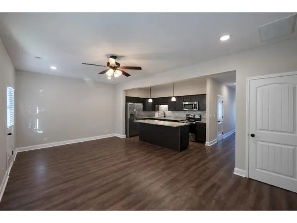 a view of a kitchen with a sink cabinets and wooden floor