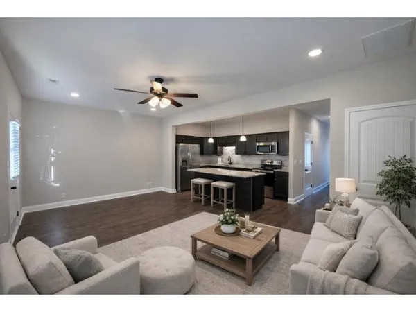 a living room with furniture and kitchen chandelier