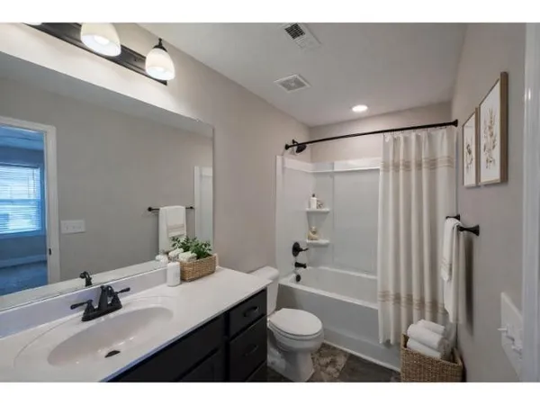 a bathroom with a double vanity sink toilet mirror and shower