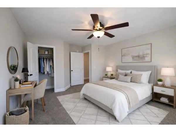 a bedroom with a bed a chandelier and a dresser