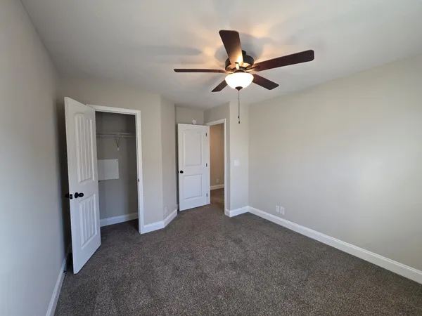 an empty room and chandelier fan
