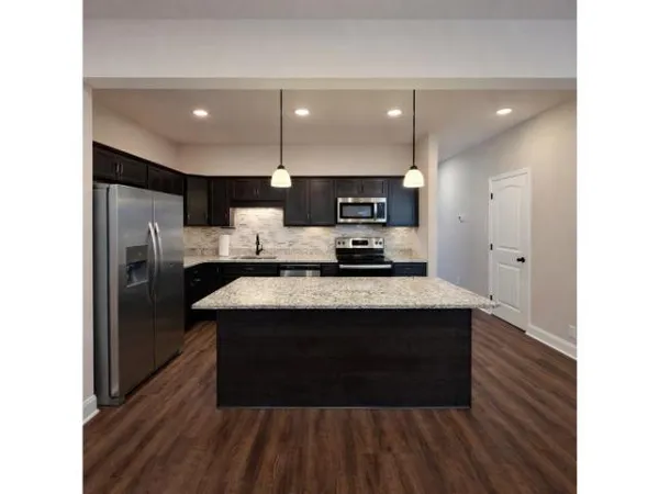 a kitchen with kitchen island a sink stainless steel appliances and cabinets