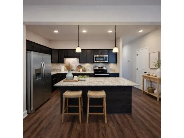 a kitchen with stainless steel appliances a kitchen island hardwood floor sink stove dining table and chairs