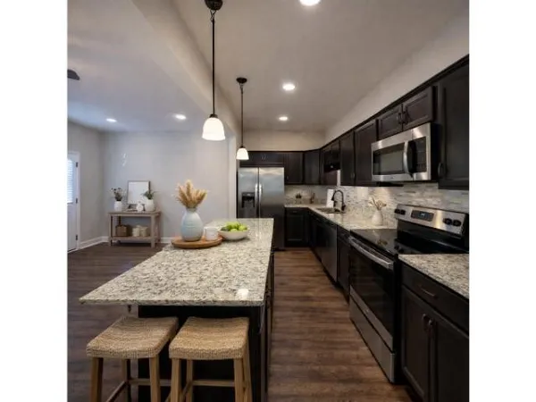 a kitchen with granite countertop kitchen island wooden cabinets and stainless steel appliances