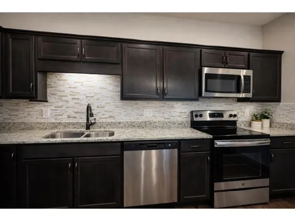 a kitchen with granite countertop a sink and a stove