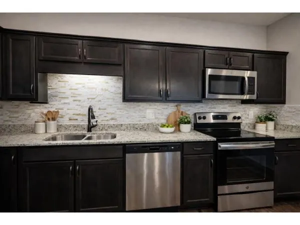 a kitchen with granite countertop a sink and cabinets