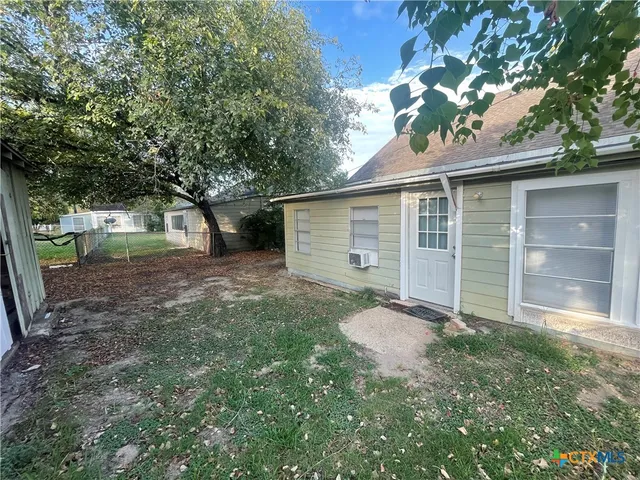 a view of backyard with a barn and a large tree