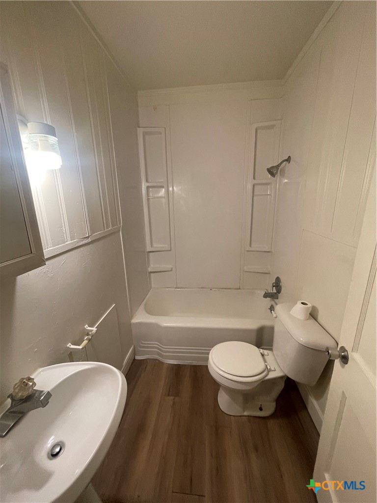 211 Lackey Street Cuero, TX 77954 - Photo 6 of 11 a bathroom with a sink a toilet a mirror and shower