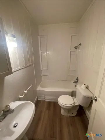 a bathroom with a sink a toilet a mirror and shower