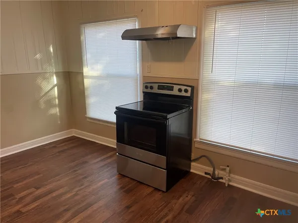 a kitchen with wooden floors and a fireplace