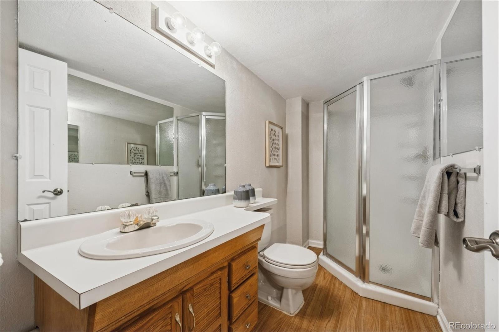 2002 South Xenia Way Denver, CO 80231 - Photo 18 of 23 a bathroom with a sink a toilet and shower