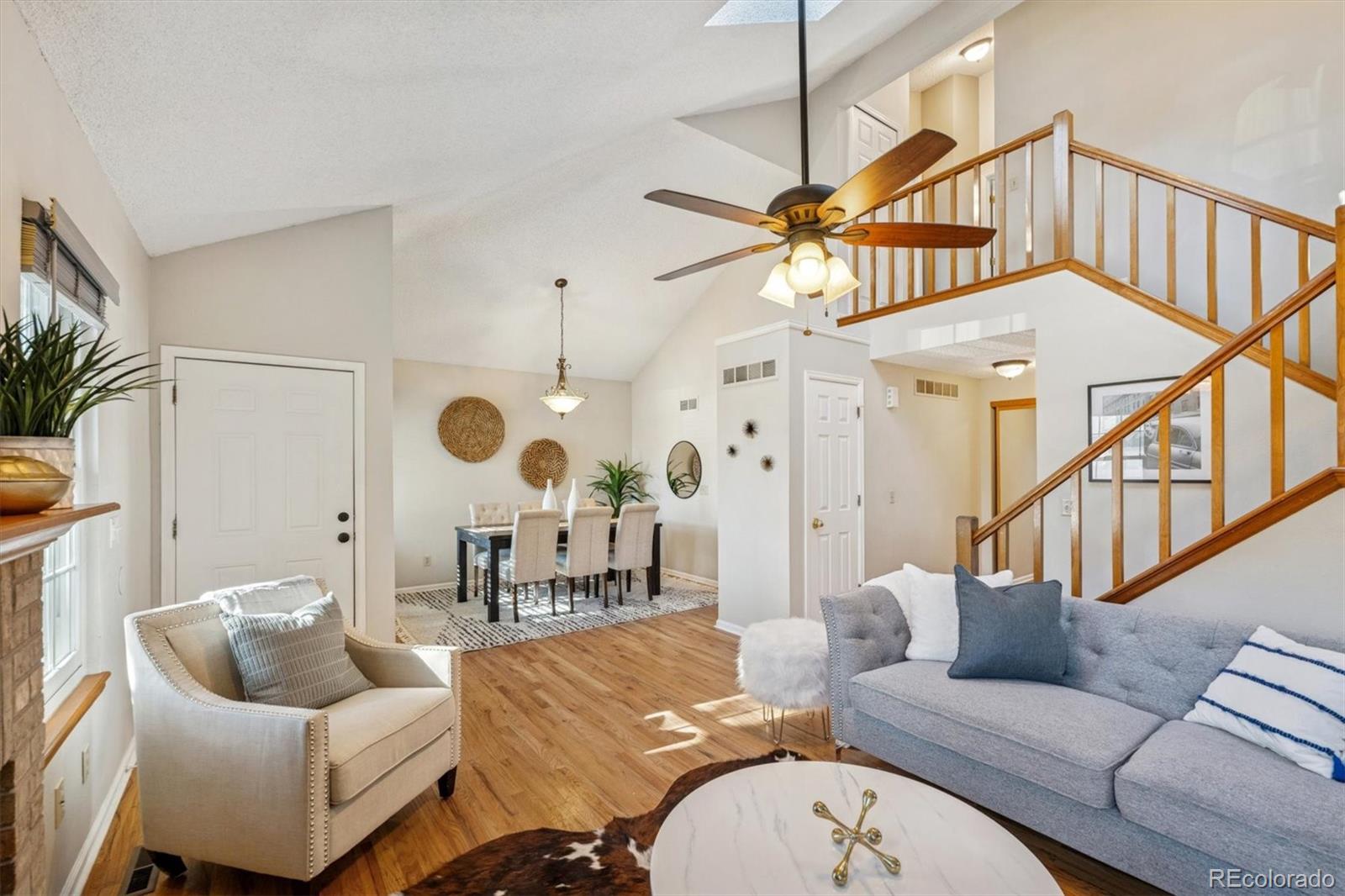 2002 South Xenia Way Denver, CO 80231 - Photo 5 of 23 a living room with furniture a rug and a chandelier