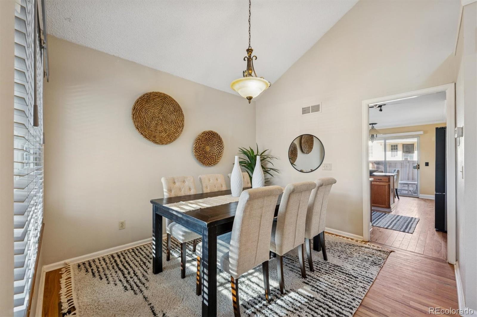 2002 South Xenia Way Denver, CO 80231 - Photo 6 of 23 a view of a dining room with furniture wooden floor and a chandelier