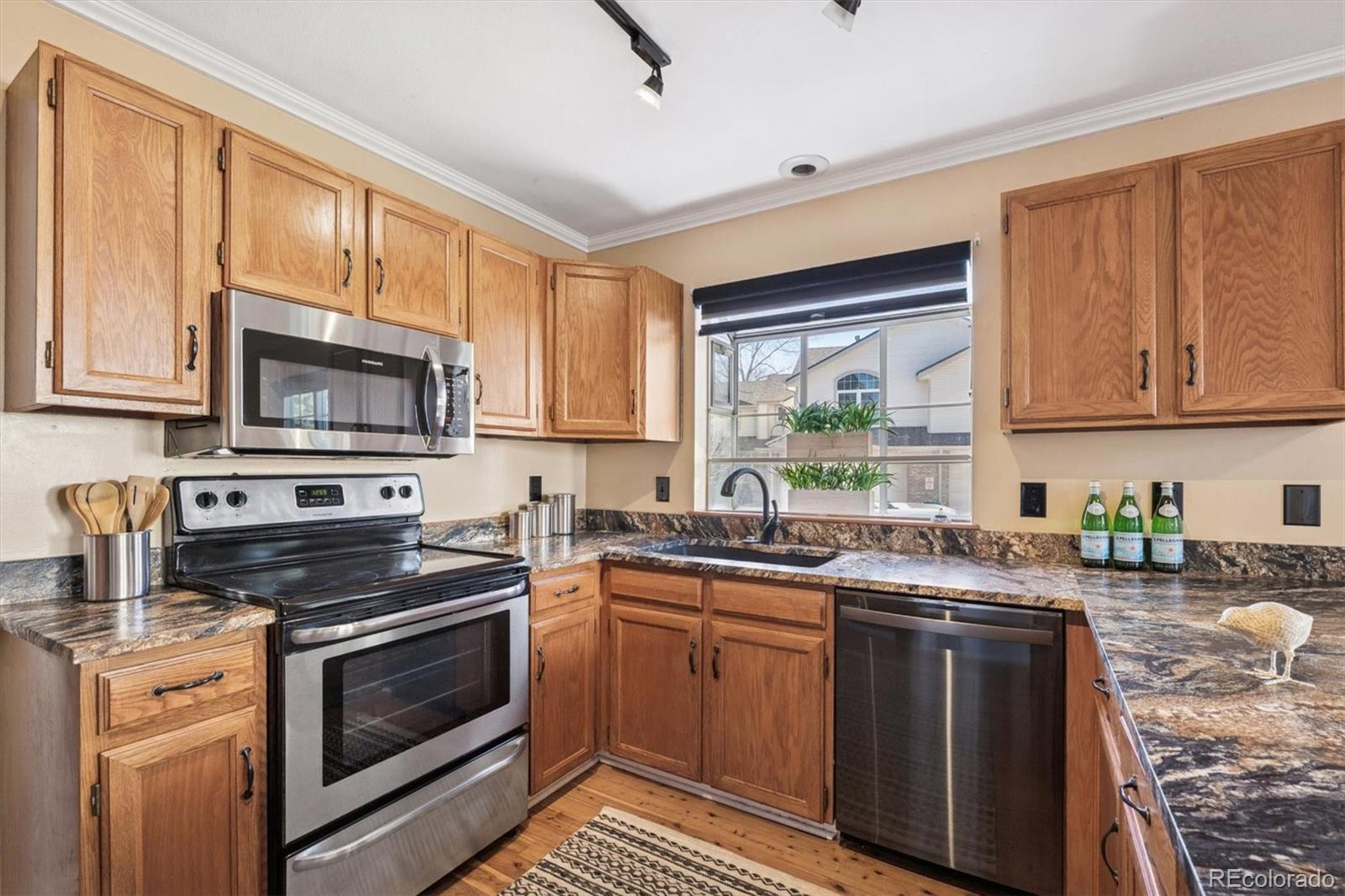 2002 South Xenia Way Denver, CO 80231 - Photo 9 of 23 a kitchen with stainless steel appliances a stove sink microwave and cabinets