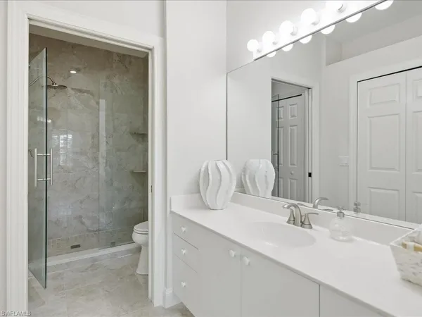 a bathroom with a shower sink vanity and mirror