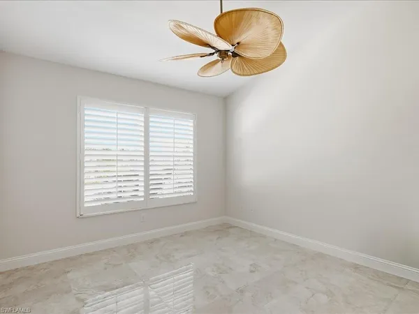 an empty room with a window and a chandelier