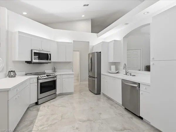 a kitchen with a sink cabinets stainless steel appliances and a counter top space