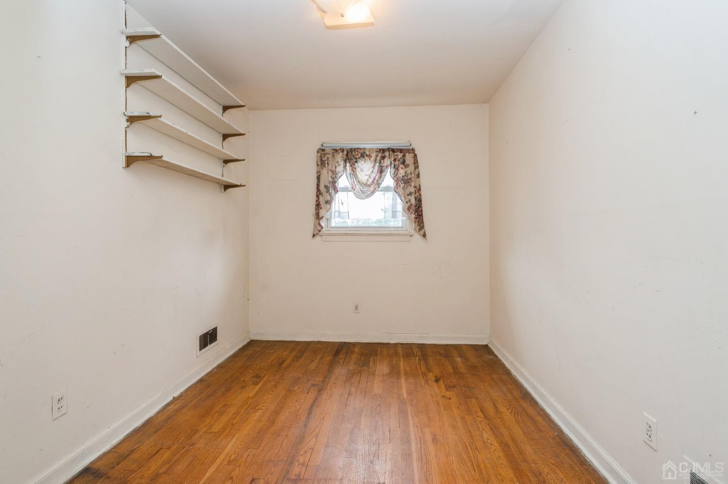2 Leland Road Edison, NJ 08817 - Photo 11 of 25 an empty room with a window and wooden floor