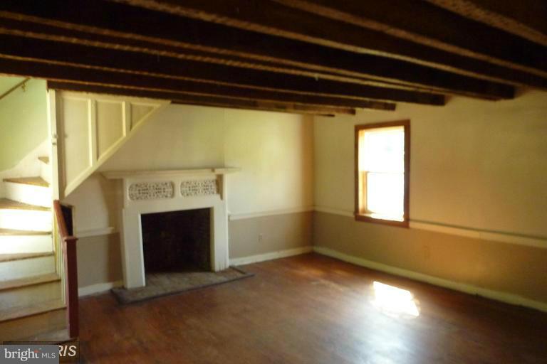 2248 Elliott Island Road Vienna, MD 21869 - Photo 2 of 10 a view of empty room with wooden floor and fireplace