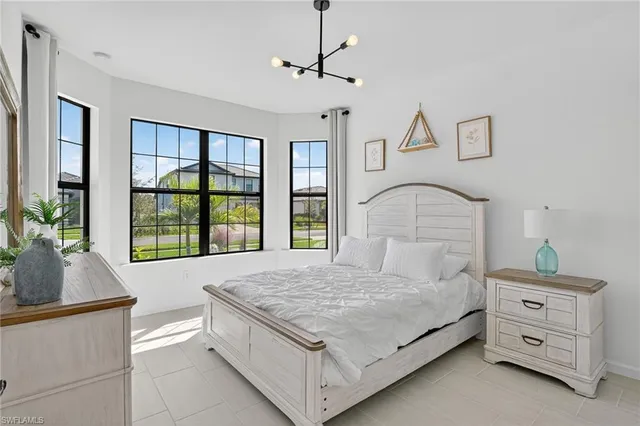 a bedroom with a large bed and windows