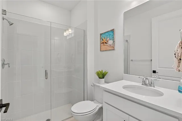 a bathroom with a granite countertop sink toilet a mirror and shower