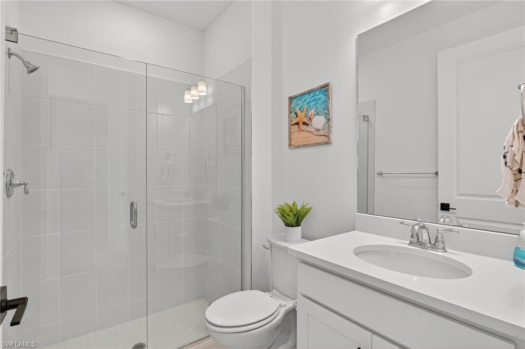 1953 Fresno Avenue Naples, FL 34120 - Photo 12 of 33 a bathroom with a granite countertop sink toilet a mirror and shower